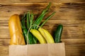 Paper bag with different food on wooden table. Top view. Grocery shopping concept Royalty Free Stock Photo