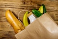 Paper bag with different food on wooden table. Top view. Grocery shopping concept Royalty Free Stock Photo