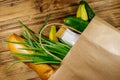 Paper bag with different food on wooden table. Top view. Grocery shopping concept Royalty Free Stock Photo