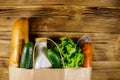 Paper bag with different food on wooden table. Top view. Grocery shopping concept Royalty Free Stock Photo