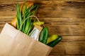 Paper bag with different food on wooden table. Top view. Grocery shopping concept Royalty Free Stock Photo