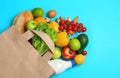 Paper bag with different groceries on blue background, flat lay Royalty Free Stock Photo