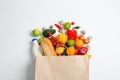 Paper bag with different groceries on white, top view Royalty Free Stock Photo