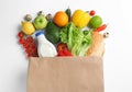 Paper bag with different groceries on white, top view Royalty Free Stock Photo