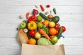 Paper bag with different groceries on white wooden table Royalty Free Stock Photo