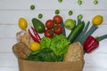 Paper bag of different health food on white wooden background Royalty Free Stock Photo