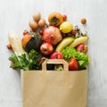 Paper bag of different health food on white wooden background Royalty Free Stock Photo