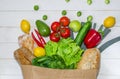 Paper bag of different health food on white wooden background. Top view. Flat lay Royalty Free Stock Photo