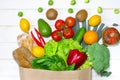 Paper bag of different health food on white wooden background. Top view. Flat lay Royalty Free Stock Photo