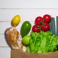 Paper bag of different health food on white wooden background. Top view Royalty Free Stock Photo