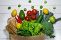 Paper bag of different health food on white wooden background. Top view Royalty Free Stock Photo