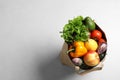 Paper bag full of fresh vegetables and fruits on light background, top view Royalty Free Stock Photo