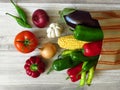 Paper bag full of juicy organic green red peppers, red tomato, purple eggplant, yellow onion, white garlic and maize. Summer.