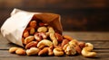 A Paper Bag Full of Mixed Nuts Spilling Onto a Wooden Surface Royalty Free Stock Photo