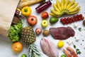 Paper bag of groceries on white wooden background, top view. Health food. Royalty Free Stock Photo