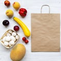 Paper bag of healthy organic food on white wooden surface. Cooking food background. Flat-lay of fresh fruits, vegetables, top view Royalty Free Stock Photo