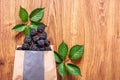 A paper bag with large blackberries.