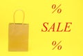 Paper bag mockup on a yellow background and the inscription SALE with percentages.