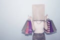 Paper bag over head of woman and carrying shopping paper bag. Royalty Free Stock Photo