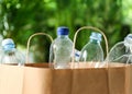 Paper bag with used plastic bottles against blurred background, closeup. Recycle concept Royalty Free Stock Photo