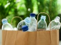 Paper bag with used plastic bottles against blurred background, closeup. Recycle concept Royalty Free Stock Photo