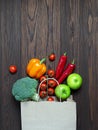 Paper bag vegetables and fruit on a dark background. Copy space, top view