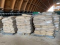 Paper bags of cement in dirty polyethylene lie on a wooden euro pallet. Building materials for the construction of the sidewalk. Royalty Free Stock Photo