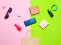 Paper bags and many purchases of gadgets and accessories on a colored background: sunglasses, smartphone, smart bracelet, powel