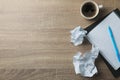 Paper balls, notebook, cup of coffee and pen on wood table Royalty Free Stock Photo