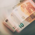 Paper bill of ten euros and a wallet. Blurred background. Royalty Free Stock Photo