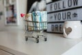 Paper bills lie in a metal mini supermarket cart