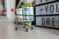 Paper bills lie in a metal mini supermarket trolley
