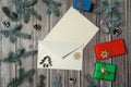 Paper blank, envelope, gift boxes, fir branches, cones, wooden decorative toys, snowflakes on a wooden background. Christmas, win Royalty Free Stock Photo