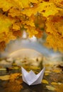 Paper boat on an autumn river