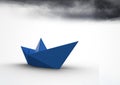 Paper boat with dark clouds Royalty Free Stock Photo