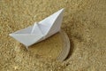 Paper boat and euro coin on the sand - Concept of immigration Royalty Free Stock Photo