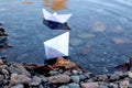 Paper boat in the river. Paper boat on the shore in the water. C