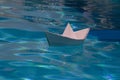 Paper boat sailing on blue water surface. Paper boat sailing on blue water surface. Concept of tourism, travel dreams Royalty Free Stock Photo