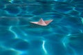 Paper boat sailing on water causing waves and ripples. Paper boat into water. Concept of tourism, travel dreams vacation Royalty Free Stock Photo