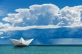 Paper Boat in the Sea under the Sky with Cumulonimbus and Torrential Rain Royalty Free Stock Photo