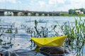 Paper boat shipwreck near rocky river bank