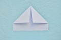 Paper boat step by step instructions. White paper on a blue background. Step 3