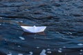 A paper boat on a turbulent stream of water struggles with the flow. Small paper boat is flowing along river Royalty Free Stock Photo