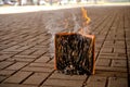 Paper book burns to ashes, on concrete tiles, manuscript burns, open book with fire Royalty Free Stock Photo