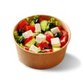 Paper bowl of greek salad with fresh vegetables, feta cheese and black olives isolated on white Royalty Free Stock Photo