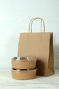 Paper bowls and paper bag on white wooden table Royalty Free Stock Photo