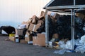 Paper boxes next to a garbage bin. Stack of paper waste outdoor in the city. Paper recycling, nobody