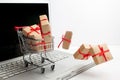 Paper boxes in a shopping cart on a laptop keyboard. Ideas about e-commerce, a transaction of buying or selling goods or Royalty Free Stock Photo