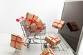 Paper boxes in a shopping cart on a laptop keyboard. Ideas about e-commerce, a transaction of buying or selling goods or Royalty Free Stock Photo