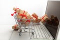 Paper boxes in a shopping cart on a laptop keyboard. Ideas about e-commerce, a transaction of buying or selling goods or Royalty Free Stock Photo